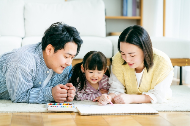仲良く子供の本を見る家族